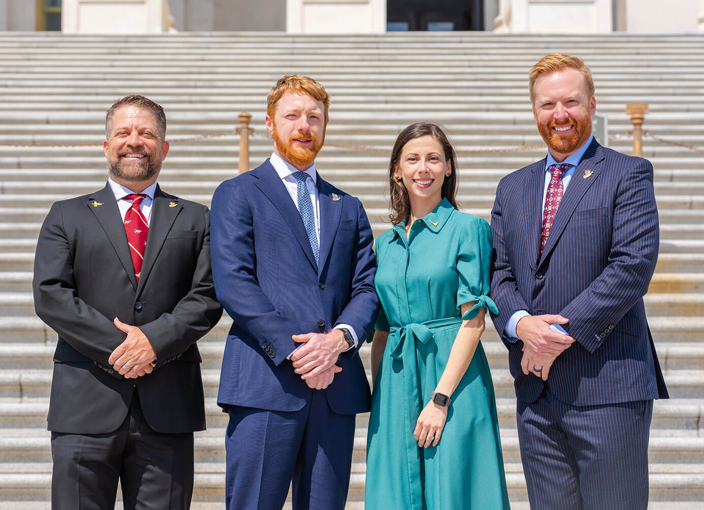 Four PF employees in front of steps in Washington D.C.